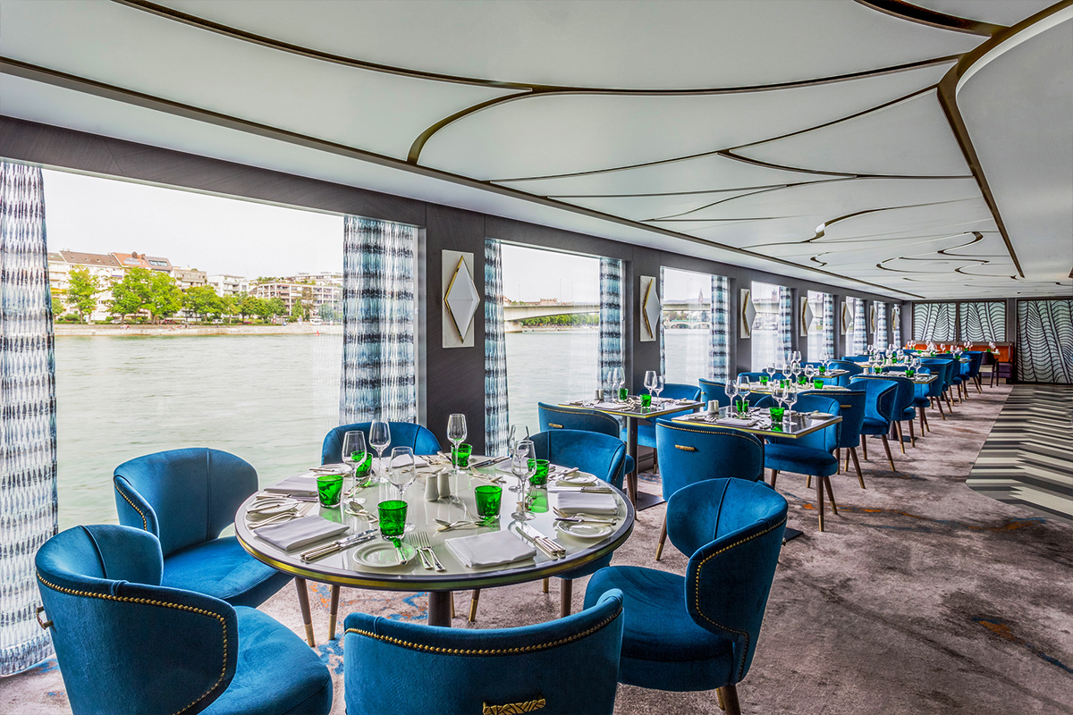 a group of tables and chairs next to a body of water