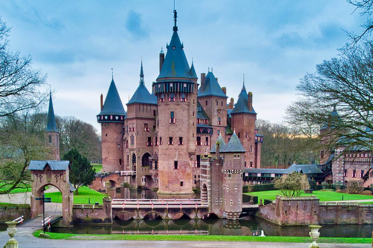 a castle with blue rooftops with Kasteel de Haar in the background