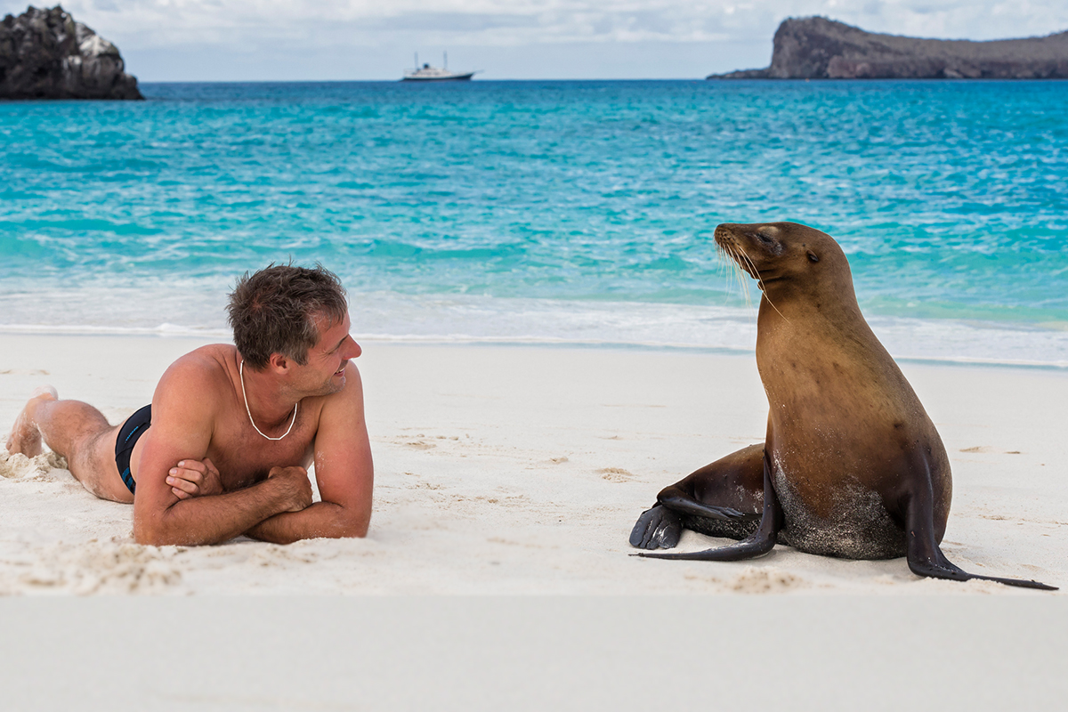 Mann und Robbe am Strand